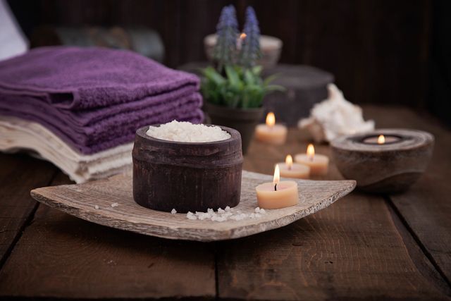 A candle lit on top of a wooden table.