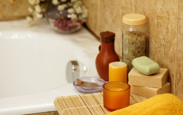 A bathroom with a sink, candles and a tub.