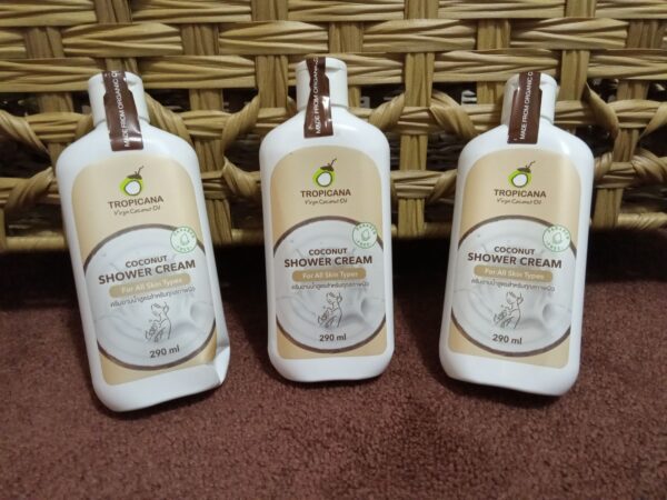 Three bottles of body lotion sitting in front of a wicker basket.